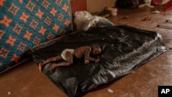 A child sleeps at the Lycee des Lumires where he found refuge, in Mamoudzou, Mayotte, Dec. 19, 2024.