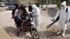 A health worker in protective gear fumigates a motorcycle near a poultry farm during a health alert due to a bird flu outbreak in Sacaba, Bolivia, Jan. 31, 2023. 