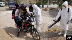 A health worker in protective gear fumigates a motorcycle near a poultry farm during a health alert due to a bird flu outbreak in Sacaba, Bolivia, Jan. 31, 2023. 