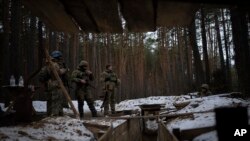 Militares ucranianos montan guardia junto a una trinchera cerca de la frontera con Bielorrusia, Ucrania, el miércoles 1 de febrero de 2023. (AP Foto/Daniel Cole)