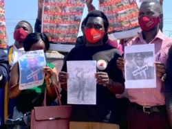 Relatives of people allegedly abducted by security forces in Uganda hold their pictures, at National Unity Platform party offices in Kampala, Uganda, Feb. 17, 2021. (Halima Athumani/VOA)
