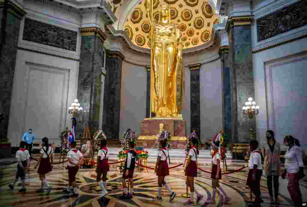 Students walk in a line as they pay their last respects to Havana's historian, Eusebio Leal, during his funeral ceremony inside the "Salon de Los Pasos Perdidos," where his ashes are on display at the Capitol in Havana, Cuba.