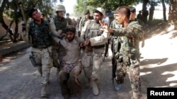 FILE - Afghan security forces escort a captured suspected Taliban insurgent during an operation in Sorkhrod district of Jalalabad province, June 19, 2013.