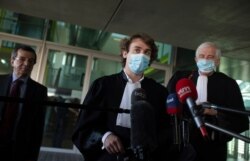 Lawyers George-Henri Beauthier, right, and Rik Vanreusel, center, representing the National Council of Resistance of Iran, speak with the media at the courthouse in Antwerp, Belgium, Feb. 4, 2021.