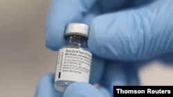 Un trabajador del Hospital Real de Victoria, en Belfast, muestra un vial de la vacuna contra la COVID-19 de Pfizer/BioNTech.