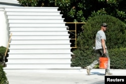 Un trabajador camina junto a las escaleras del pórtico sur de la Casa Blanca después de una renovación, 22 de agosto de 2017.