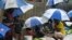 Rohingya refugees hide under umprellas during rainfall at Kutupalong refugee camp in Ukhia, Cox's Bazar, Bangladesh, Sept. 12, 2019. 
