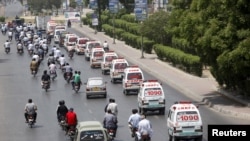 Barisan ambulan membawa jenazah korban serangan bis ke lokasi pemakaman di Karachi, Pakistan (14/5).