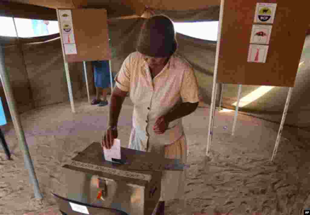 Un électeur dépose son bulletin de vote à un bureau de vote à Gaborone, au Botswana, le vendredi 24 octobre 2014. Les agents électoraux disent que le vote a commencé sans incident où des analystes estiment que le parti au pouvoir va gagner malgré le mécontentement croissant dans les zones urbaines. 