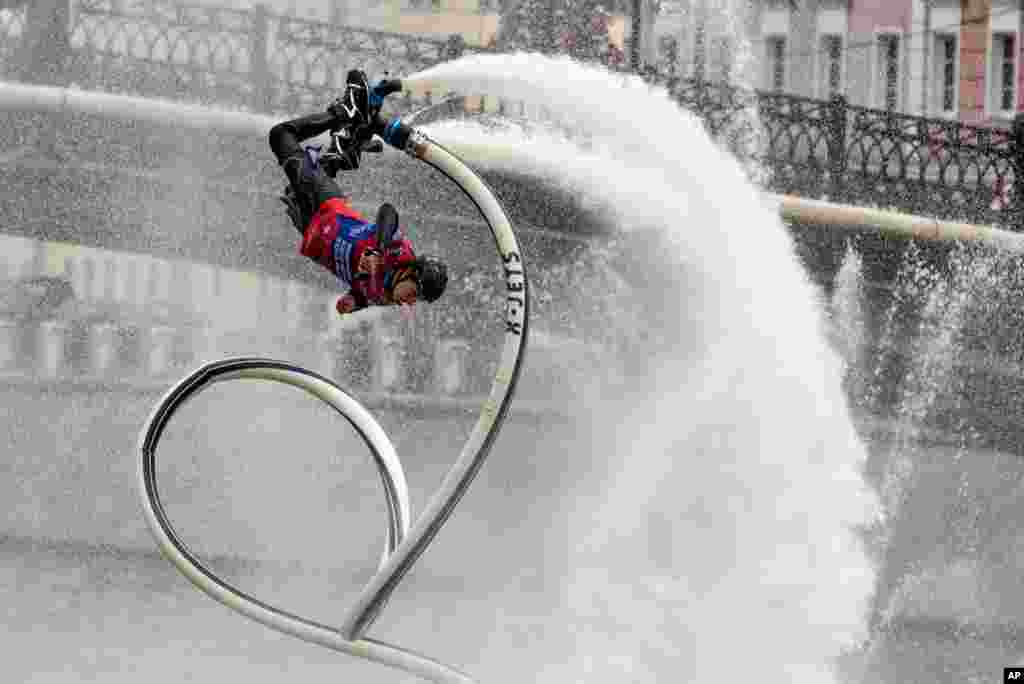 Andrei Smirnov performs on a hydro pipe on the Moscow River Channel during a SUP (Stand Up Paddle)-Surfing festival in Moscow, Russia, Sept. 19, 2020.