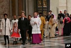 The first pilgrims pass through after Pope Francis opened the Holy Door to mark the opening of the 2025 Catholic Holy Year, or Jubilee, in St. Peter's Basilica, at the Vatican, Dec. 24, 2024.