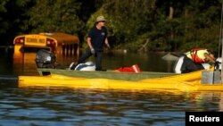 Workers fix containment booms in a flooded area as a result of Hurricane Matthew in Lumberton, North Carolina, Oct. 10, 2016. 