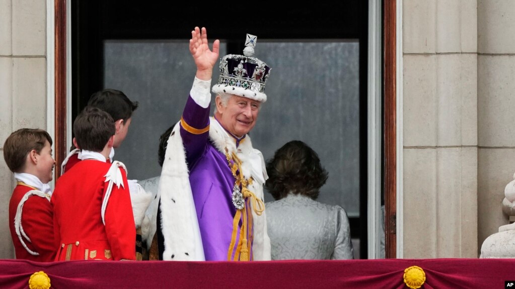 El rey Carlos III saluda a las multitudes tras salir del balcón del Palacio de Buckingham, en Londres, después de la coronación este sábado 6 de mayo de 2023.