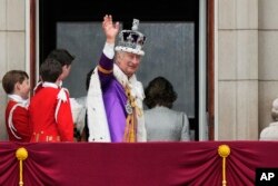 El rey Carlos III de Gran Bretaña saluda a la multitud desde el balcón del Palacio de Buckingham después de la ceremonia de coronación en Londres, el sábado 6 de mayo de 2023. (Foto AP/Frank Augstein)