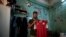 In this May 9, 2020 photo, 28-year-old defender Mahrous Mahmoud holds up his Egyptian national football team jersey he trains with, inside his home, in Manfalut, a town 350 kilometers (230 miles) south of Cairo in the province of Assiut, Egypt.