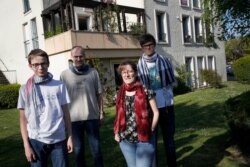 In this photo taken April 16, 2020, Jerome, second left, Nadege and their children Thomas, 17, right and Pierre, 14, pose outside their home in Montigny-le-Bretonneux, near Paris.