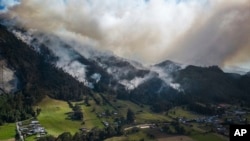 El humo se eleva desde un incendio que arde en las laderas de las montañas que rodean Nemocón, al norte de Bogotá, Colombia, el 23 de enero de 2024.