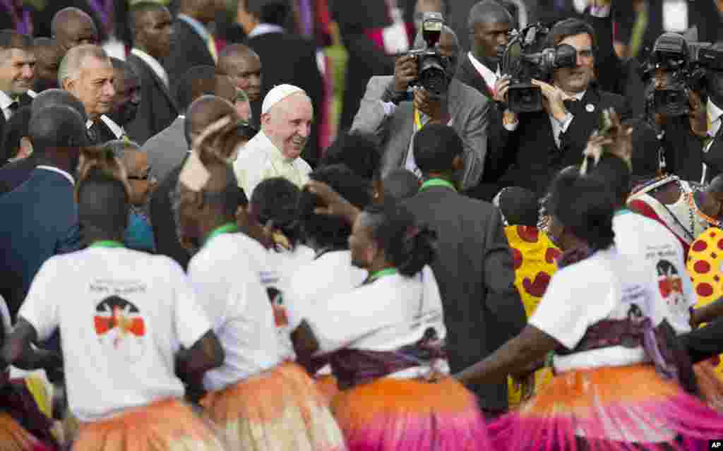 Pope Francis greets traditional dancers on his arrival at the airport in Nairobi, Kenya. Pope began&nbsp; his first-ever visit to Africa, a whirlwind pilgrimage to Kenya, Uganda and the Central African Republic, bringing a message of peace and reconciliation to an Africa torn by extremist violence.