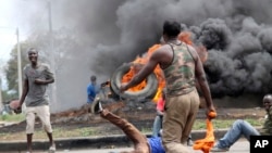 FILE - Opposition supporters burn tires and barricade roads as they fight anti-riot police at Samaria, Kisumu, Kenya, Oct. 26, 2017. 