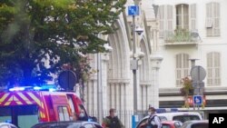 Policías franceses de pie junto a la iglesia de Notre Dame tras un ataque con arma blanca en Niza, Francia, el jueves 29 de octubre de 2020.