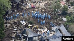 在日本南部熊本地震造成的泥石流摧毁了数座住房，救援人员正在对一所倒塌的房子进行搜救。 (2016年4月16日)