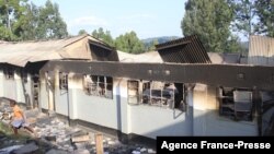 FILE - A boy walks by a burnt out dormitory building at a high school for boys in Kisii county, Kenya, June 26, 2016. The structure was set on fire by students during a night of unrest. Some 35 schools across Kenya have been set on fire in the last month.