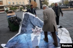 Pria berjalan melewati poster Assad yang dibersihkan setelah pemberontak mengumumkan penggulingannya di Damaskus, 10 Desember 2024. (Foto: Reuters)