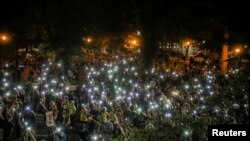 Los manifestantes iluminan con sus teléfonos móviles las cercanías del Palacio de Justicia Federal en la ciudad estadounidense de Portland, Oregon, en donde han estado protestando por dos meses contra el racismo y la violencia policial.