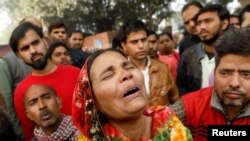 A relative of a victim of a fire that swept through a factory where laborers were sleeping, cries outside a hospital mortuary in New Delhi, India, Dec. 8, 2019. 