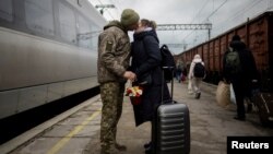 Ukrainian serviceman Vyacheslav greets his wife, Viktoria, who is visiting him during a short break from his frontline duty at the train station in Kramatorsk, Ukraine, on Dec. 22, 2023.