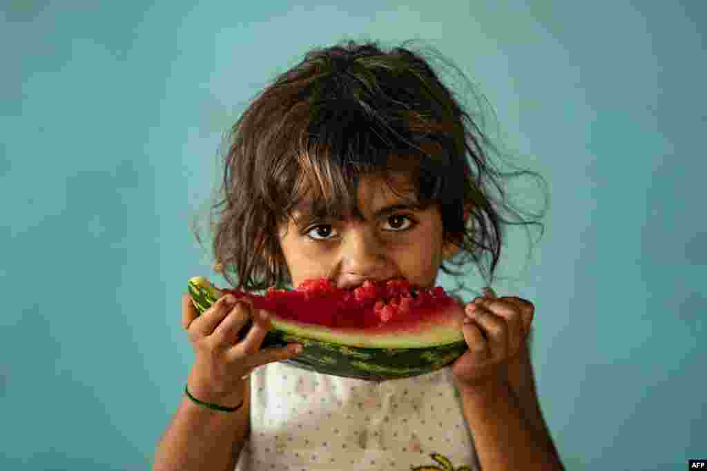 A girl eats watermelon at a school building in the city of Hasakah where Syrians -- displaced from the area of Ras al-Ain by the Turkish offensive on the northeast, are staying.