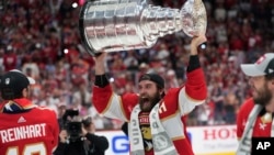 Florida Panthers defenseman Aaron Ekblad raises the NHL hockey Stanley Cup trophy after defeating the Edmonton Oilers in Game 7 of the Final, June 24, 2024, in Sunrise, Fla.
