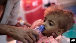 ယီမင်နိုင်ငံ၊ Hodeida ဆေးရုံပေါ်မှာ သမီးလေးကို ရေတိုက်နေတဲ့ဖခင်တဦး။ 