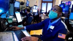 Trader Aaron Ford works on the floor of the New York Stock Exchange, July 19, 2021. Resurgent pandemic worries knocked stocks lower from Wall Street to Tokyo on Monday.