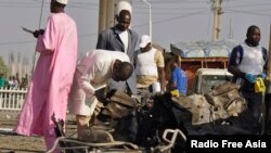 Para pakar bom menyelidiki lokasi ledakan di kantor poisi di Kano (15/11/2014) dimana terjadi bom bunuh diri yang menewaskan 6 orang termasuk 3 polisi. Militan Boko Haram diduga berada di balik serangan itu. 