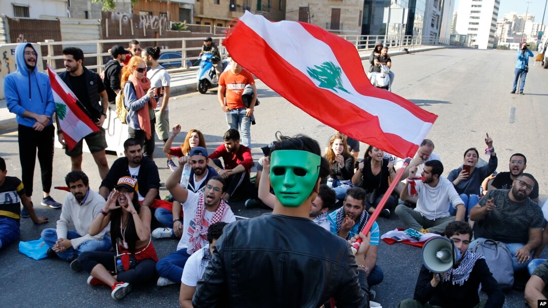 Para pengunjuk rasa anti-pemerintah meneriakkan slogan-slogan menentang pemerintah Lebanon saat memblokir jalan raya utama di Beirut, Senin, 4 November 2019.