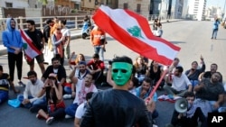 Para pengunjuk rasa anti-pemerintah meneriakkan slogan-slogan menentang pemerintah Lebanon saat memblokir jalan raya utama di Beirut, Senin, 4 November 2019.