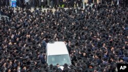Thousands of ultra-Orthodox Jews participate in the funeral for prominent rabbi Meshulam Soloveitchik, in Jerusalem, Jan. 31, 2021.
