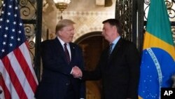 FILE - In this March 7, 2020, file photo, President Donald Trump, left, shakes hands before a dinner with Brazilian President Jair Bolsonaro at Mar-a-Lago in Palm Beach, Fla.