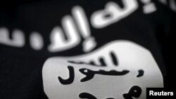 FILE- An Islamic State flag is captured in this photo illustration.