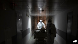 Para pekerja medis membawa seorang pasien virus corona ke unit perawatan intensif di Rumah Sakit Kota Filatov di Moskow, Rusia, 15 Mei 2020. 