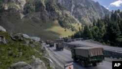 FILE - An Indian army convoy moves along the Srinagar-Ladakh highway at Gagangeer, northeast of Srinagar, Indian-administered Kashmir, Sept. 9, 2020. Control over the Ladakh border region is a key friction point between India and China.