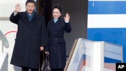 Presiden China Xi Jinping dan ibu negara Peng Liyuan saat tiba di bandar udara Vnukovo II, di luar kota Moskow. (AP/Ivan Sekretarev)