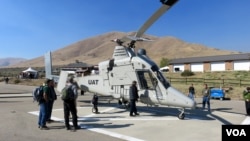 Federal firefighting managers peruse the “optionally piloted” K-MAX helicopter at the Lucky Peak Helibase in Idaho. (Credit: Tom Banse)