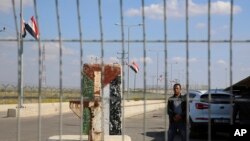 FILE - An employee of the Palestinian Authority stands guard on the Palestinian side of the Erez checkpoint between Israel and Gaza, at Beit Hanoun, Gaza Strip, Nov. 1, 2017. 