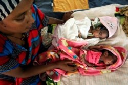 FILE - An Ethiopian woman who fled the ongoing fighting in Tigray region, nurses her newly born children inside a clinic in the Hamdayat camp in eastern Kassala state, Sudan, Dec. 15, 2020.
