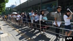 2018年7月26日在美國使館大院外發生爆炸後，簽證服務一度中斷，然後恢復，人們在美國大使館外面排隊申請簽證資料照。