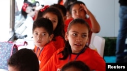 Migrant children take English lessons at a bus converted in a classroom as part of Schools On Wheels program by California's 'Yes We Can' organization, in Tijuana, Mexico, Aug. 2, 2019. 