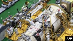 FILE - A handout photograph released by the Russian Space Agency Roscosmos July 21, 2021, shows workers preparing the module "Nauka" (Science) at the Baikonur cosmodrome in Kazakhstan. The module docked at the International Space Station Thursday.