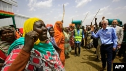 Le Secrétaire général adjoint aux affaires humanitaires et Coordonnateur des secours d'urgence Mark Lowcock, à droite, discute avec des déplacés soudanais dans un camp près de Kadugli, la capitale du Sud Kordofan, 13 mai 2018.